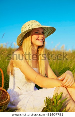 stock photo : Beautiful young girl in white dress with basket in field on summer picnic