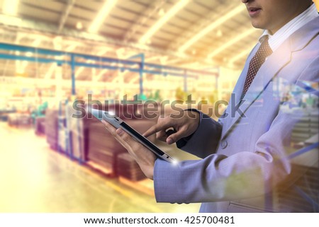 Double exposure authorities Quality Inspector use tablet inspecting a small manufactured part and factory with blur background Factory Plant bulbs
