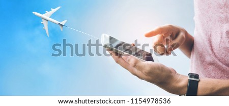 Travel trip concepts with male hand using smartphone,mobile and airplane on sky.Booking flight ticket content ideas