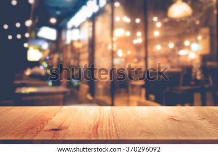 Wood table  on blur bokeh cafe or restaurant background(in night) .For product display template