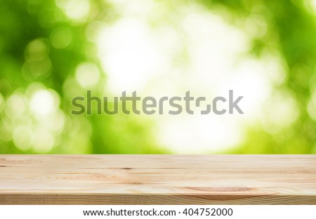 Wood table top and blur of  fresh green bokeh from garden background .For product display and natural concept
