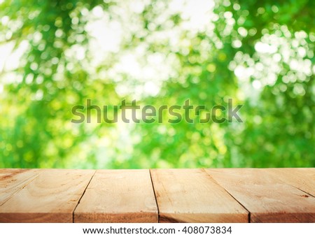 Empty of wood table top on blur of fresh green abstract background .For montage product display or design key visual layout