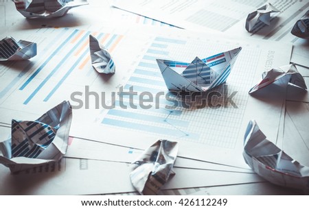 Group of boat made with paper graph in stormy of business.Only one boat can be success.Business success concept.