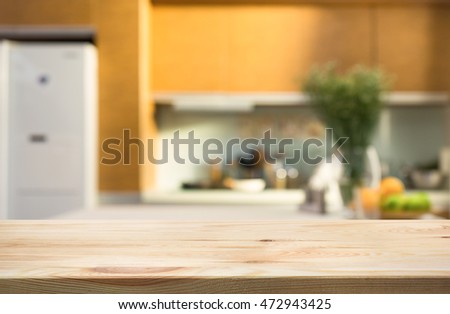 Wood table top with blur kitchen room interior in morning background .For montage product display or design key visual layout.