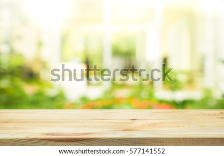 Empty wood table top on blur abstract green from garden and house in morning background.For montage product display or design key visual layout