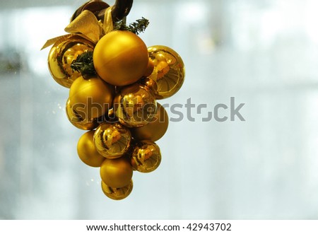 Gold Christmas ornament hanging with plain background for text.