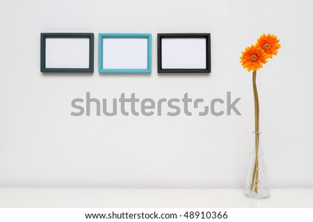 Picture Frame for Home Decoration. Three photo frames on white wall. Potted plants on white table.