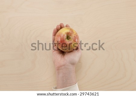 Apple for Effort - hand holding apple on desk