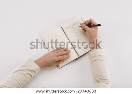 Cons and Pros - notebook sitting on desk with pro's and con's list  on white background