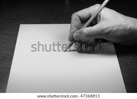 Hand holding pencil on paper