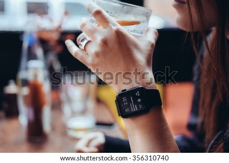 Young woman drinking with smart watch