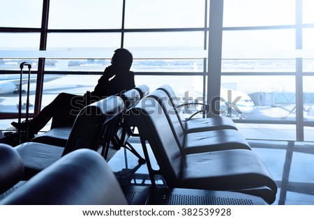 Beijing,China - Feb 25,2016:Asian business man on the phone silhouette in airport teminal.