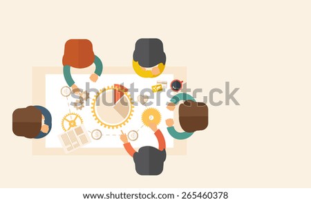 A meeting  of a business people sitting facing each other in the office with coffee and papers on the table in front of them. Sharing and gathering ideas for their marketing plan. Teamwork concept.