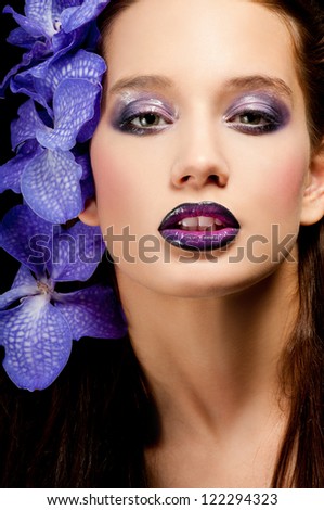Fashionable beautiful woman with orchid in her hair