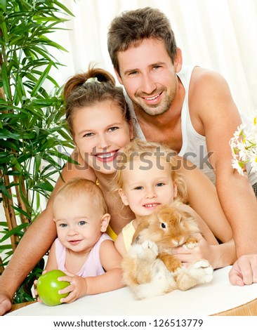 Young happy family with a pet rabbit