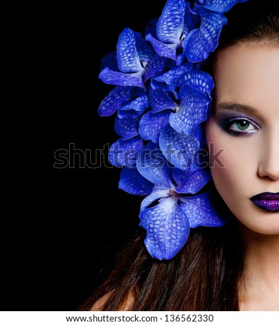 Fashionable beautiful woman with orchid in her hair