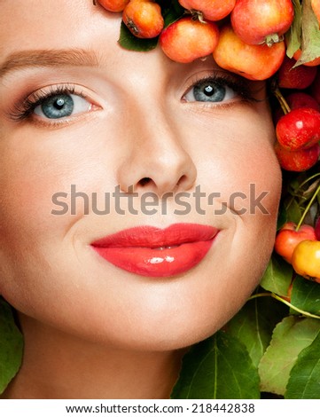 Beautiful  woman with green leaves and apples in her hair