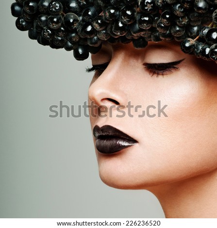 beautiful female face. professional makeup. black berries.