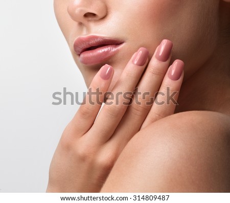 Beautiful Young Woman with Clean Fresh Skin. Close up Portrait.  Fashion Model Girl Face. Perfect Skin. Professional Makeup. Fashion shiny highlighter on skin, sexy gloss lips. Perfect manicure.