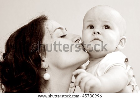 A mother kissing her cute baby son
