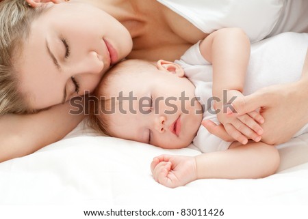 Young mother and her baby, sleeping in bed