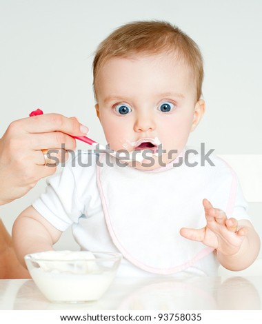 Mum spoon-feeds the child - stock photo