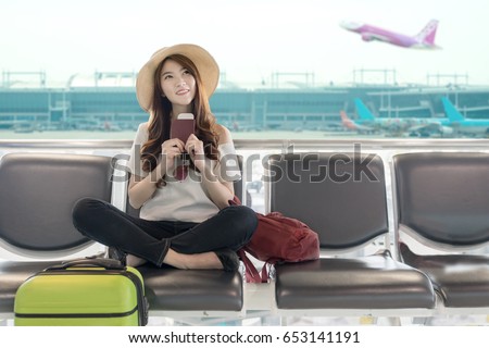 Cute asian student college traveler feeling happy action with travel plan and waiting for flight at airport terminal. Teenager travel concept