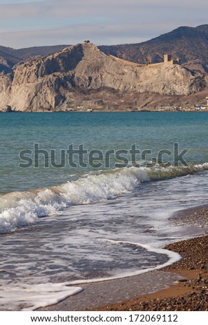 Waves on the beach against the backdrop of coastal mountains
