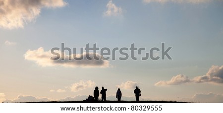 People go to heaven. Silhouettes of four people in the background of sky with clouds at sunset