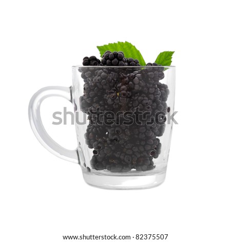 Blackberries in clear cup with green leaves. Isolated on a white background
