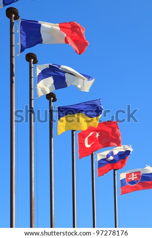 Flags of different countries are developing on the flagpoles