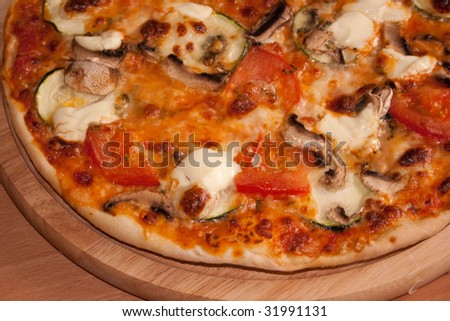 Pizza from the furnace with Zucchini, mushrooms, tomato, schmant, Mozarella pieces and rubbed cheese