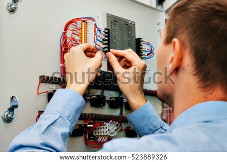 Electrician near the low-voltage cabinet. Uninterrupted power supply. Electricity.