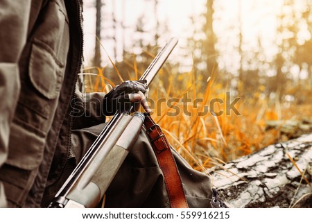 Autumn hunting season. Woman hunter with a gun. Hunting in the woods.