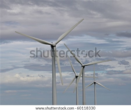 Four giant 2 megawatt wind turbines against a dramatic sky