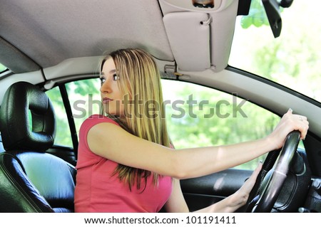 Beautiful girl in a car looking behind