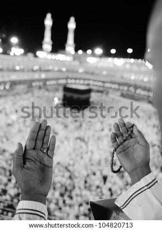 Muslim praying at Makkah holy Islamic place - Kaaba is visible