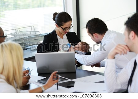 Business people taking care of baby in office