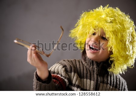 Closeup portrait of cute kid wearing yellow hair wig