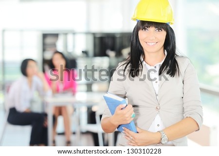 Portrait of a young successful female engineer with helmet