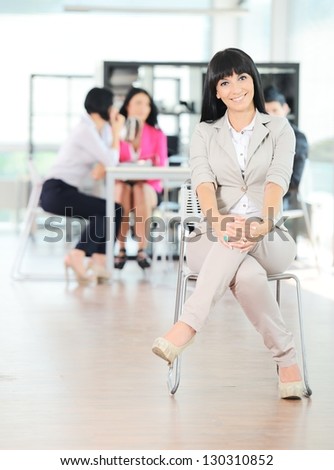 Portrait of a young successful business woman with her team at office