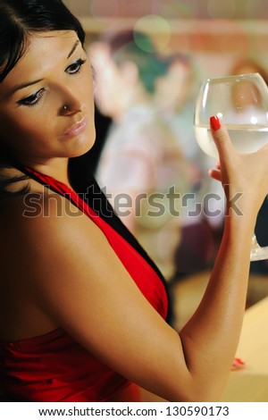 Lonely beautiful sad woman on party holding glass and drinking