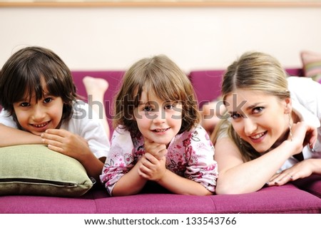 Young mom and her little son together on couch in living room