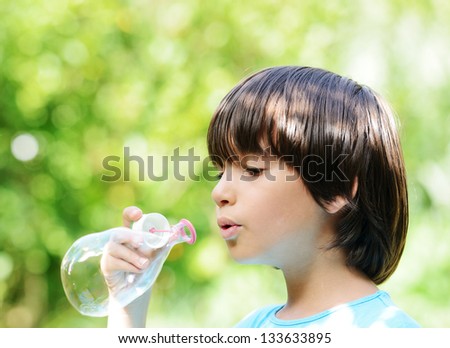 Portrait of cute child making soap bubbles