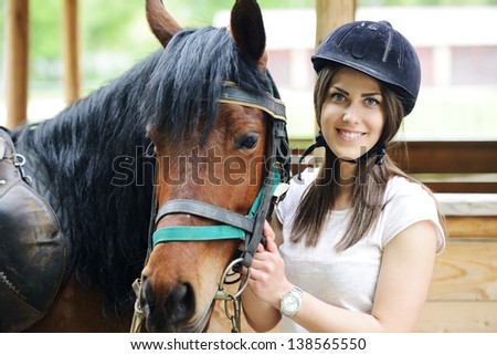 Beautiful girl riding taking a care of a horse on farm