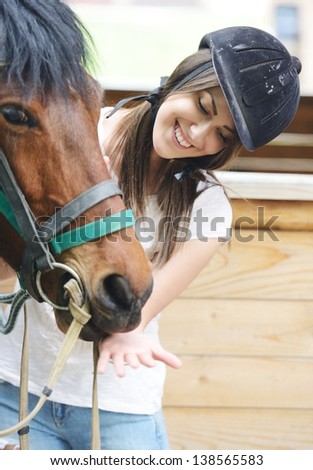 Beautiful girl riding taking a care of a horse on farm