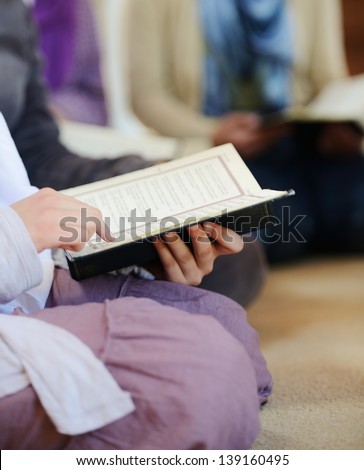 Muslim and Arabic girls reading Koran together in group