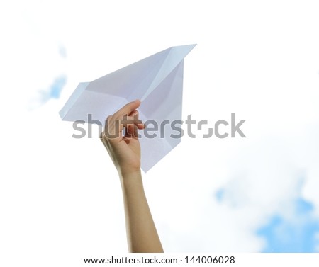 Boy holding a paper airplane dreaming about flying and traveling