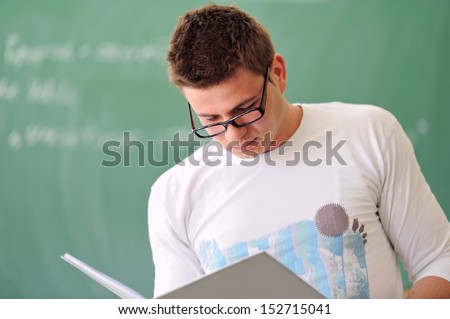 Student in a white shirt reading a copybook