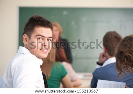 Well dressed smiling student sitting in a classroom